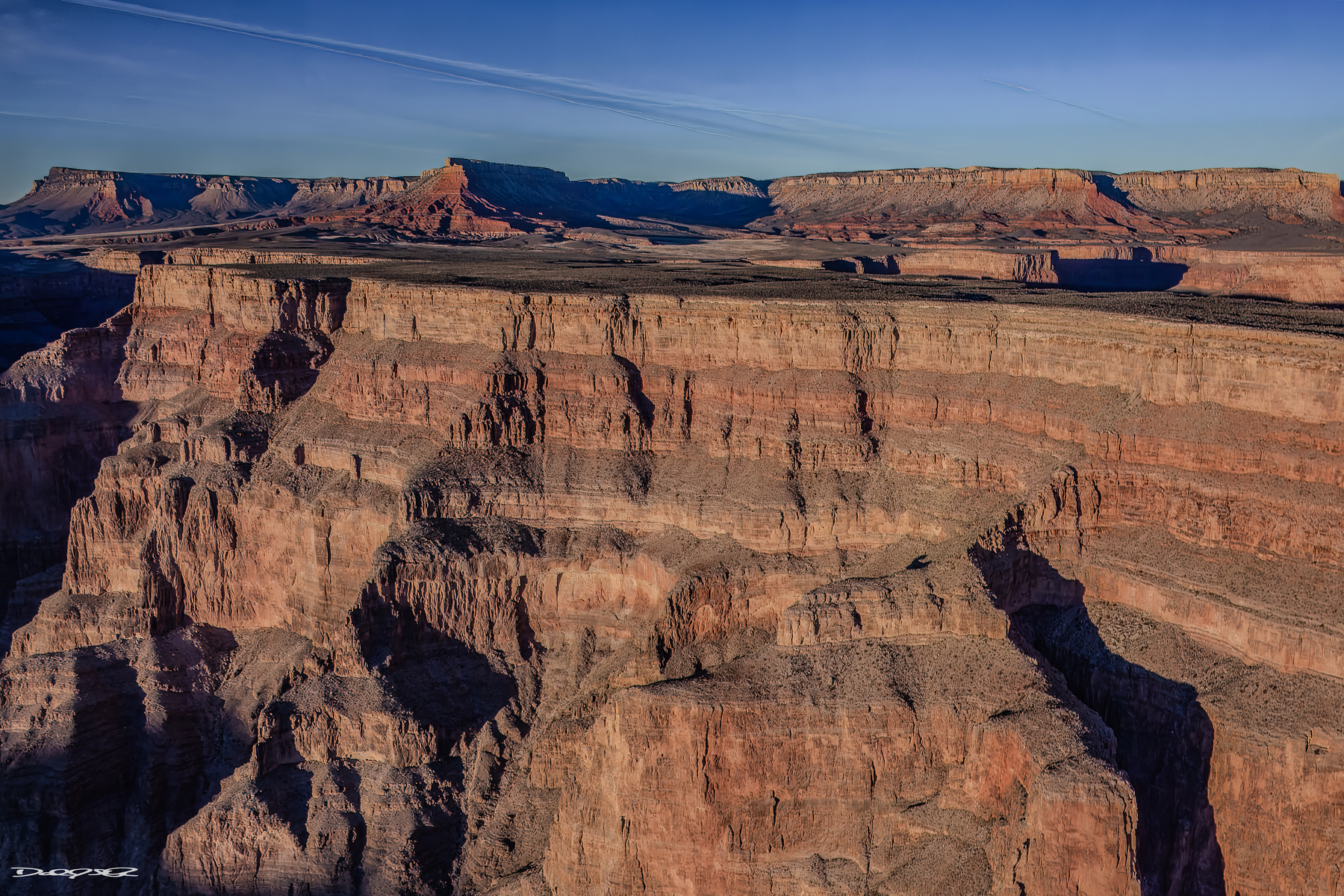 A dramatic aerial view showcases the deep layers and rugged formations of the Grand Canyon.